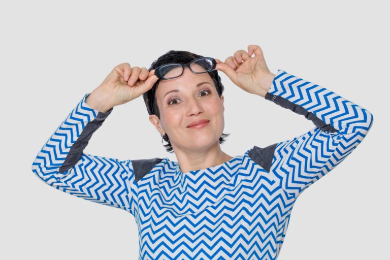 Excited woman lifting up her eyeglasses